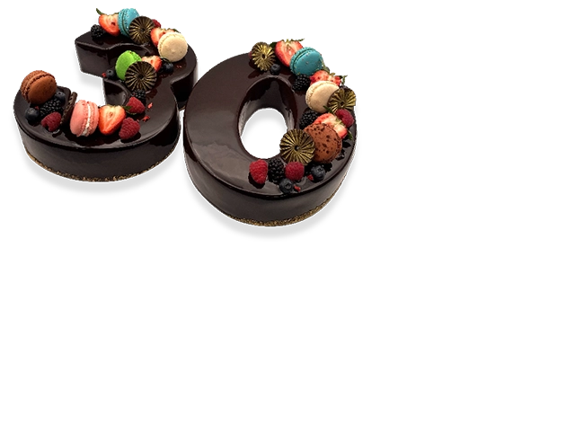 A pair of French chocolate number cakes, beautifully decorated with chocolate ganache, fresh berries, and edible flowers.
