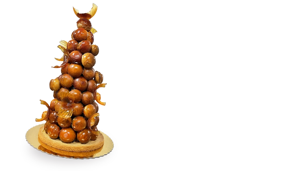A towering Croquembouche Cake, a masterpiece of French pastry artistry, adorned with spun sugar and filled with luscious cream-filled profiteroles.